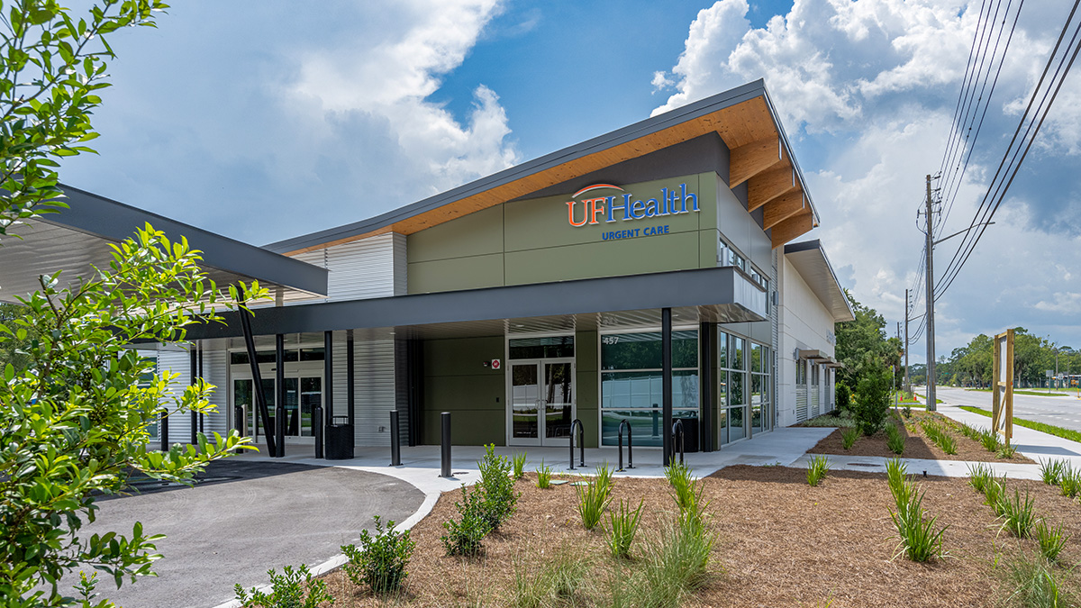 A modern building with a sloped wooden roof, housing a UF Health Urgent Care facility.