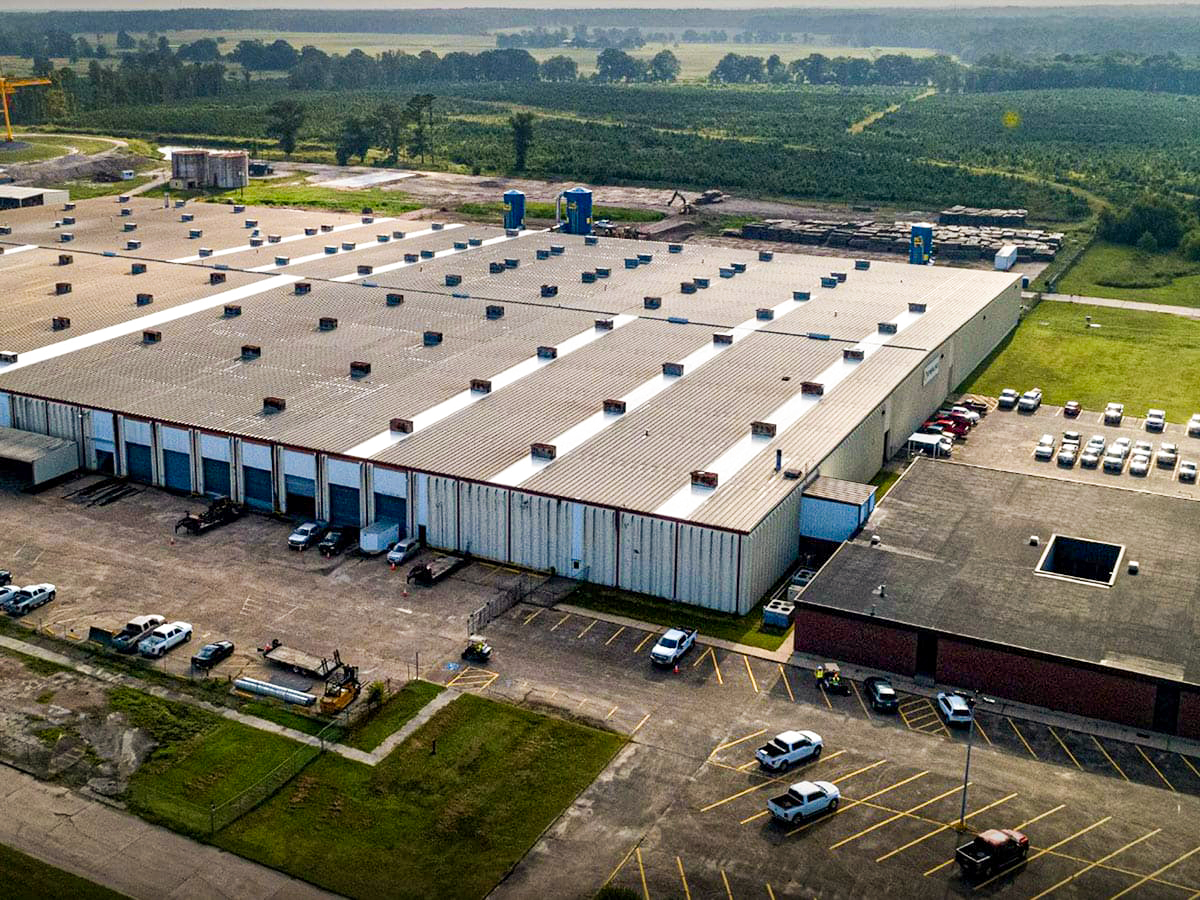 Aerial view of Sterling's Lufkin facility, featuring a large industrial building, parking lots, and surrounding green fields.